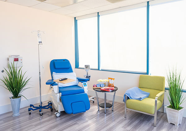 State-of-the-art infusion center offers private or community infusion suite reclining infusion chair, guest chair, blankets, snacks, book and decoration