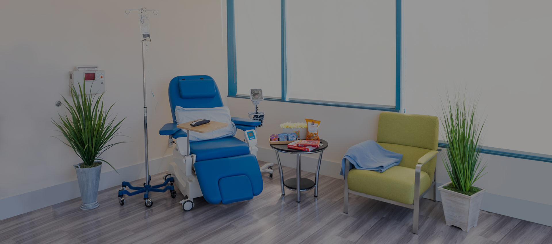 State-of-the-art infusion center suite with reclining infusion chair, guest chair, snacks, books and decoration