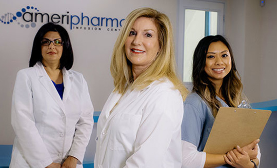 Friendly staff in lab coats stand before AmeriPharma IV infusion center logo.