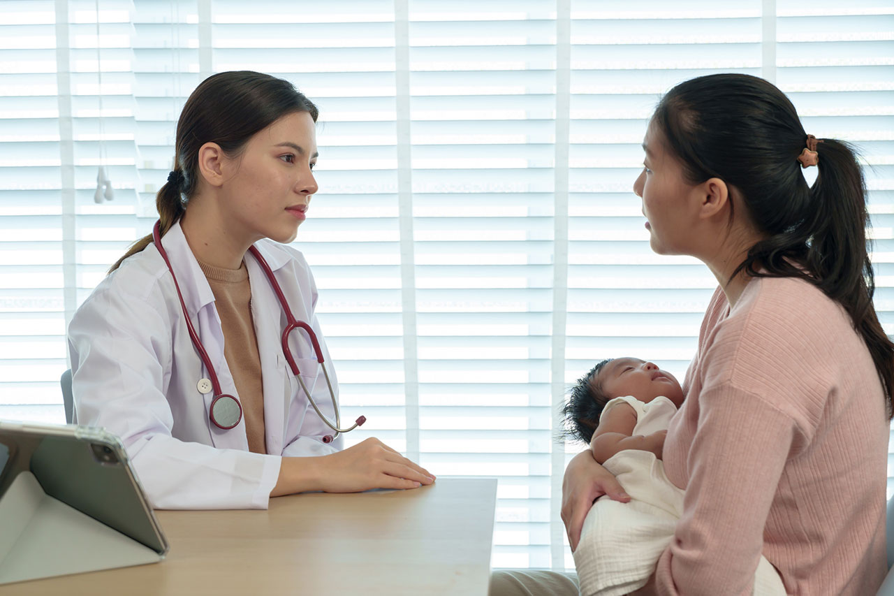 Doctor consulting with the parent of an infant with Pompe disease