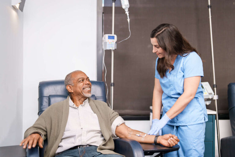 Nurse checking on patient receiving an infusion