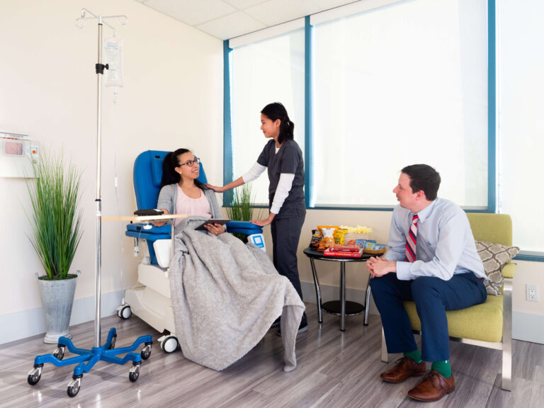 Patient and visitor being visited by nurse at an infusion IV lounge
