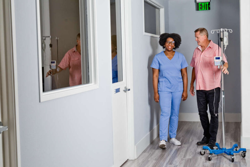 Nurse and patient in infusion center hallway