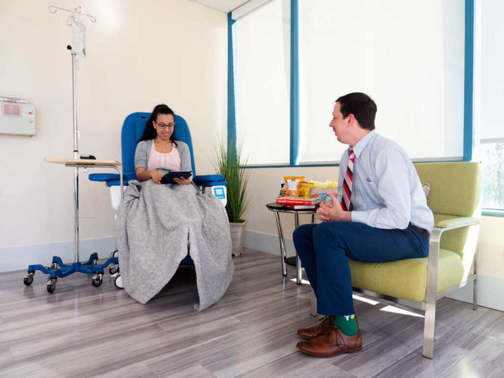 Patient receiving infusion, accompanied by guest