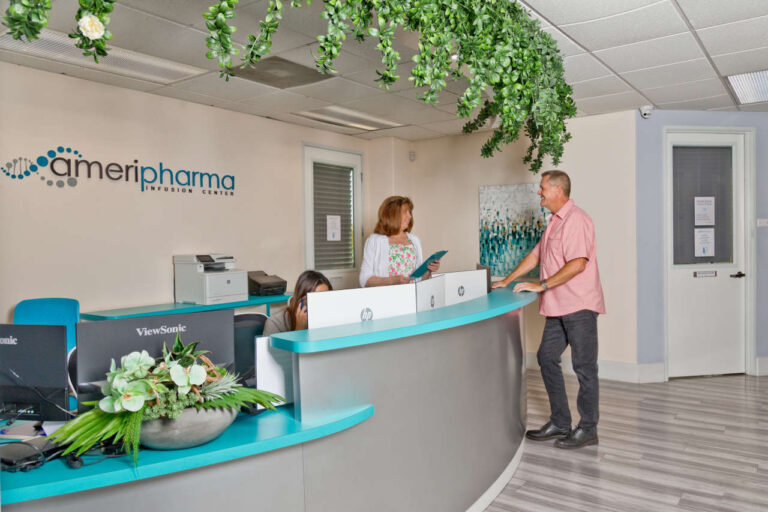 Patient discussing IV infusion cost with receptionist at AmeriPharma Infusion Center.