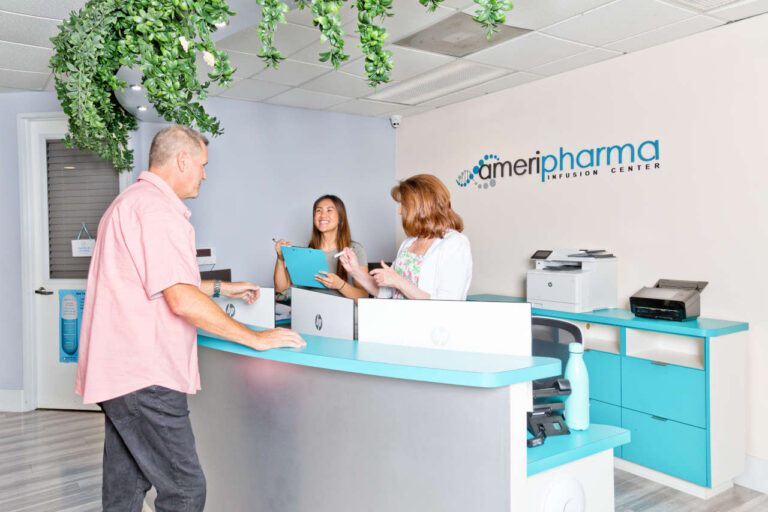 Patient talking to healthcare workers in an infusion center lobby about insurance